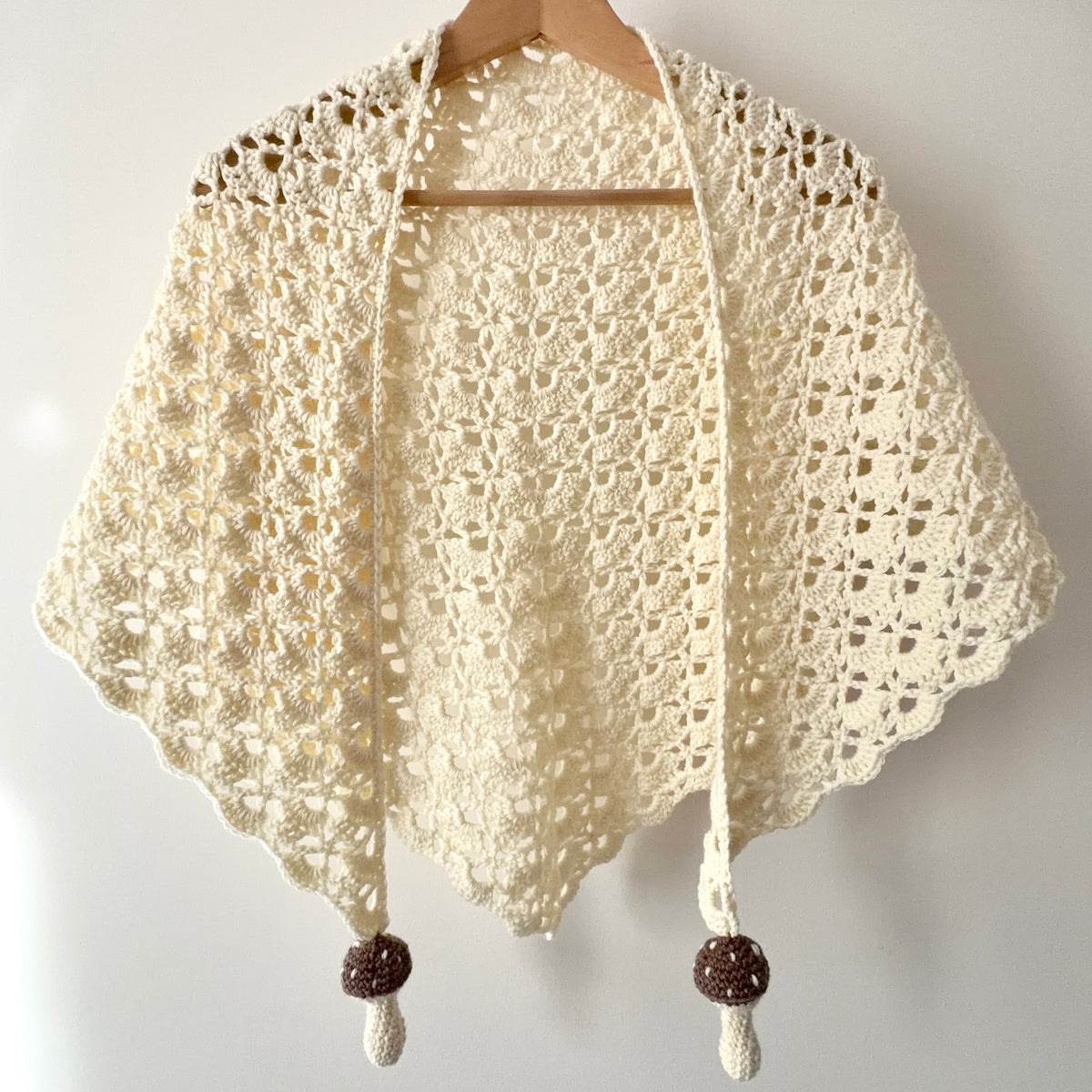 Handmade crochet shawl in cream colour with lace scallop details and mushroom charms